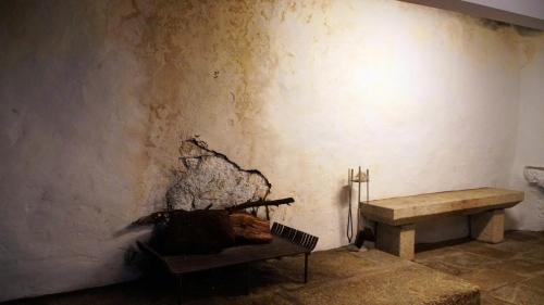 a room with a bench next to a wall at Casa Abrigo do Lagar in Amares