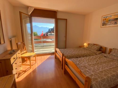 um quarto com uma cama e uma grande janela em Alpine apartment in Swiss village of Torgon em Torgon