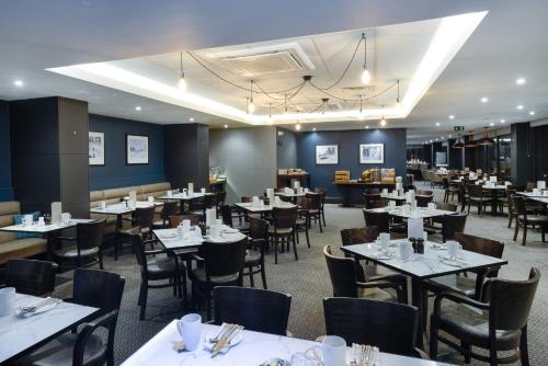 a dining room with white tables and chairs and tablesktop at Crowne Plaza Plymouth by IHG in Plymouth