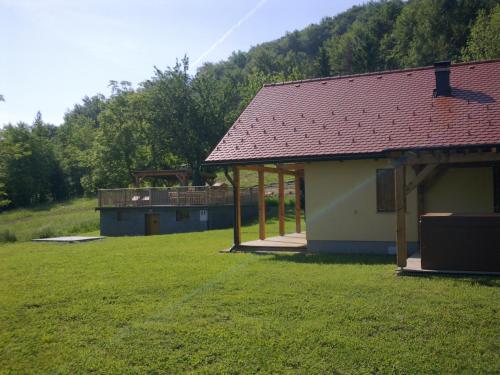 a building with a roof on a grass field at Gozdarjeva koča nad Rimskimi Toplicami in Dol pri Hrastniku