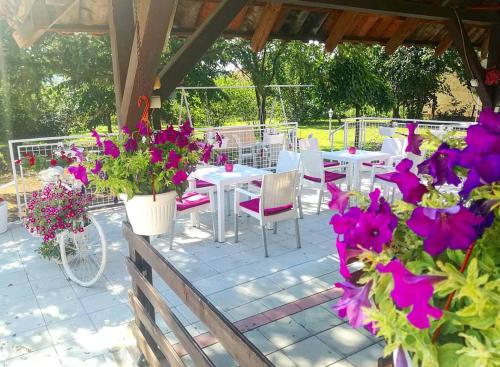 a patio with tables and chairs and purple flowers at Maslina Rooms in Smederevo