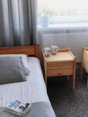 a bedroom with a bed and a table with a book at Noclegi Jachtklub Elbląg in Elblag