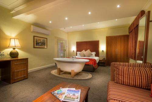 a hotel room with a bed and a bath tub at The White Hart Hotel, Boston, Lincolnshire - The Coaching Inn Group in Boston