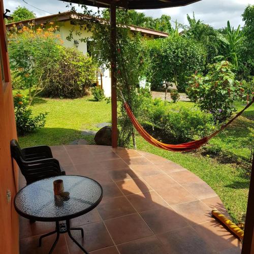 Un patio con mesa y sillas y una hamaca. en CASITA COLIBRIS, en Copecito