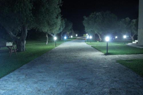 a walkway at night with lights in a park at Masseria Un Posto al Sole in Otranto