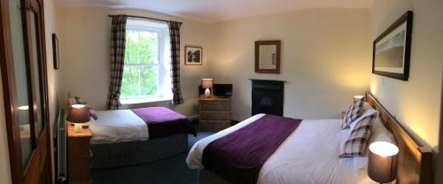 um quarto de hotel com duas camas e uma janela em Old Water View em Patterdale