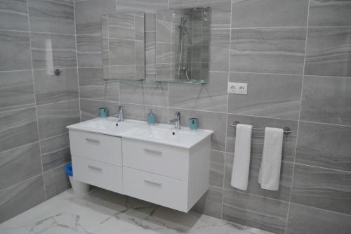 W łazience znajduje się biała umywalka i lustro. w obiekcie Genius Apartments w Alicante