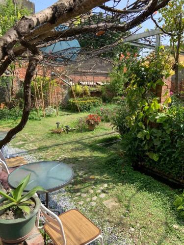a patio with a table and chairs in a garden at A Day in Lukang Homestay in Lugang