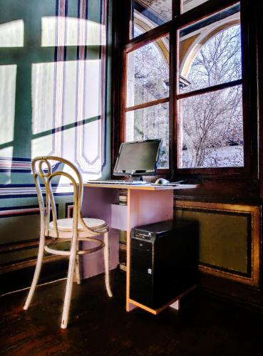 a desk with a computer and a chair in front of a window at Guest House Old Plovdiv in Plovdiv