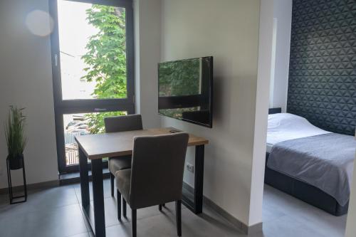 sypialnia ze stołem, łóżkiem i oknem w obiekcie Apartamenty Dworcowa 45 w mieście Gliwice