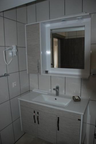 a white bathroom with a sink and a mirror at Bursa Park Apart Hotel in Bursa