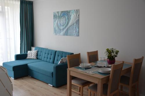Turkusowe Marzenie في غدانسك: غرفة معيشة مع أريكة زرقاء وطاولة
