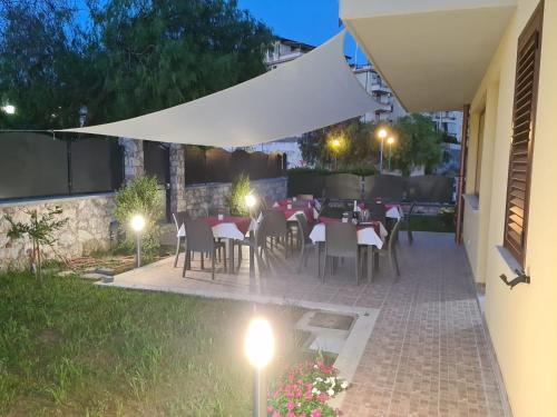 a patio with tables and chairs under a white umbrella at B&B Villa Chiara - Bed And Breakfast in Taormina