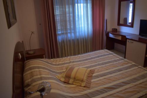 a bedroom with a large bed with a window at Villa Mia Suites in Ohrid