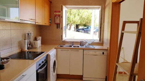 a small kitchen with a sink and a window at T2 Cabanas Gardens piscina e praia in Cabanas de Tavira