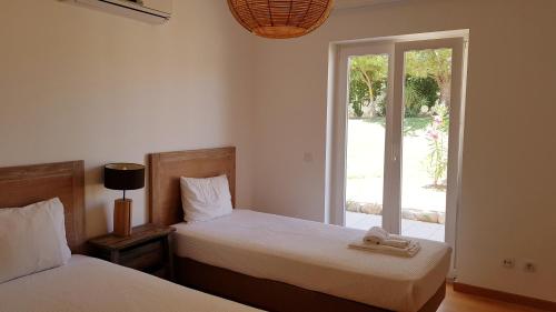 sypialnia z 2 łóżkami i ręcznikami w obiekcie T2 Cabanas Gardens piscina e praia w mieście Cabanas de Tavira