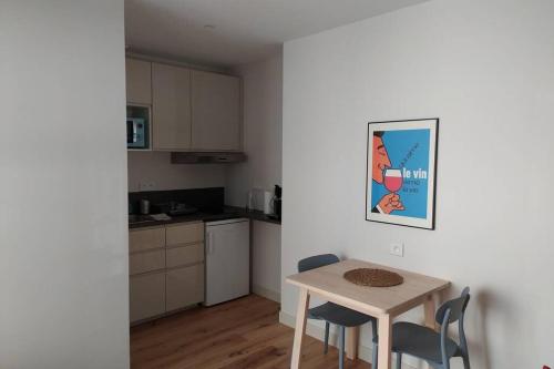 a small kitchen with a table and chairs in a room at Appartement neuf centre historique in Bordeaux