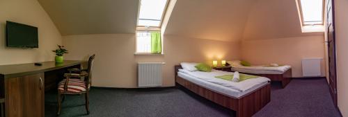 Mały pokój z 2 łóżkami i biurkiem w obiekcie Pokoje Gościnne z łazienkami w Niepołomicach