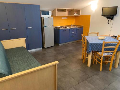 a kitchen with a table and a kitchen with blue cabinets at Residence Dei Fiori in Pietra Ligure