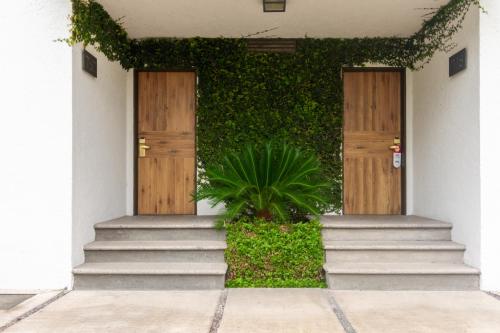 a building with two wooden doors and a plant at Hotel Flamingo Inn in Querétaro