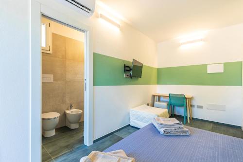 a bathroom with a toilet and a sink at Affittacamere Resort Beach San Gemiliano in Àrbatax