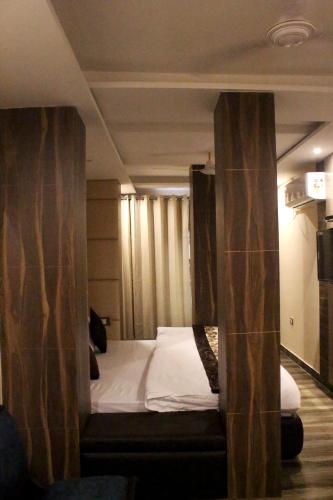 a room with a bed in a room with curtains at Perfectstayz Premium Ganga Heights at Harkipauri Road in Haridwār