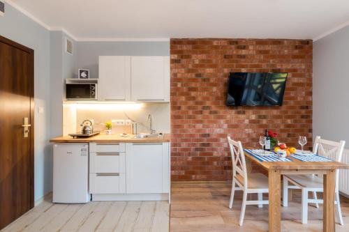 a kitchen with a table and a brick wall at Villa Kliwer 50 metrów od morza in Rowy