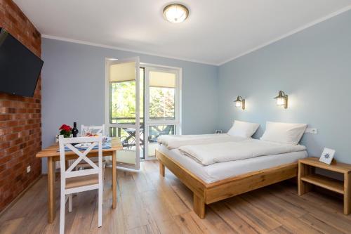 a bedroom with a bed and a desk and a window at Villa Kliwer 50 metrów od morza in Rowy