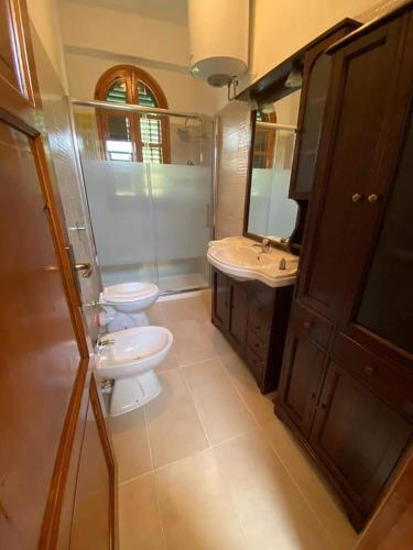 uma casa de banho com 2 WC, um lavatório e um espelho. em Casa Vacanza em Trabia