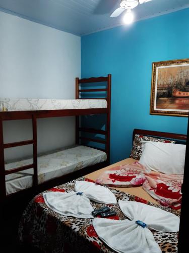 2 stapelbedden in een kamer met blauwe muren bij Pousada da Helena Trindade in Trindade