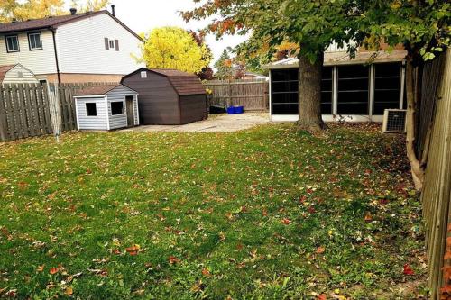 a yard with a tree and a house at Sarnia's Hidden Gem - 3 BR/2 BA by College/Hwy/Arena in Sarnia