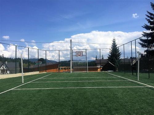 a tennis court with a net and a basketball hoop at Готельний комплекс Парламент, Яблуниця in Yablunytsya