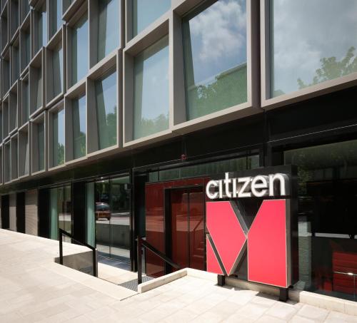 a building with a sign in front of a store at citizenM Amsterdam South in Amsterdam
