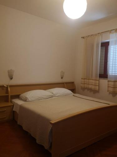 a bedroom with a bed with a light on it at Apartments Jerić in Božava