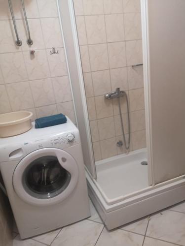 a bathroom with a washing machine and a shower at Apartments Jerić in Božava