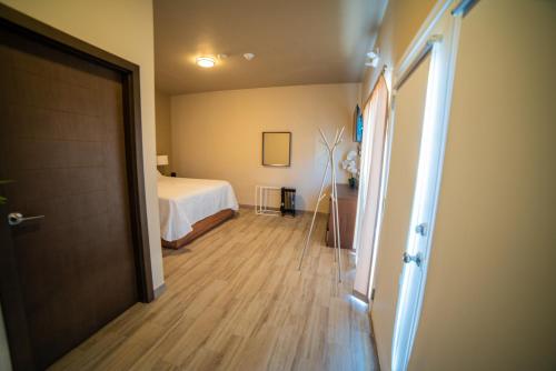 a bedroom with a bed and a hallway with a door at California Comfort & Suites in Los Algodones