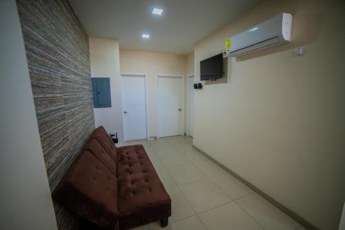 a waiting room with a brown couch and a wall at California Comfort & Suites in Los Algodones
