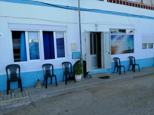a group of chairs sitting outside of a building at SonegaHostel in Sonega