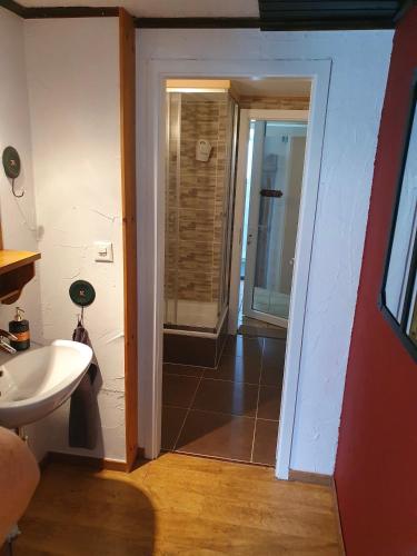 a bathroom with a sink and a door to a room at Le Petit Beurre de cacahuète et Le Poivre et Sel in Fully