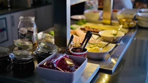 a buffet line with dishes of food on a counter at Fosen Fjord Hotel in Å i Åfjord