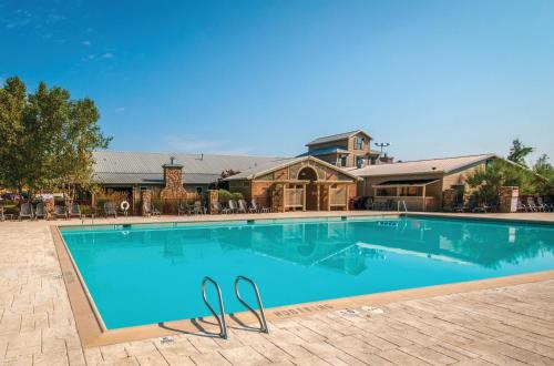 ein Pool mit zwei Flip-Flops neben einem Haus in der Unterkunft Holiday Inn Club Vacations Apple Mountain Resort at Clarkesville in Clarkesville