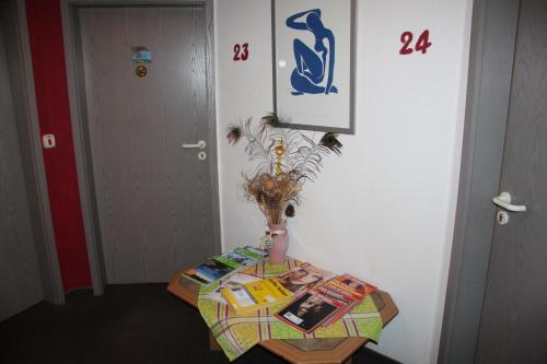 a table with books on it next to a door at Hotel am Schloss Neuenstein in Neuenstein