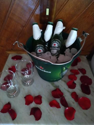 a table topped with a bucket of champagne and red roses at Pousada Recanto das Águas in Lumiar