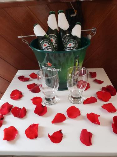 a table with wine bottles and red rose pedals at Pousada Recanto das Águas in Lumiar