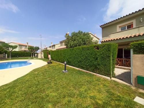 a yard with a hedge next to a house at Mallorca in Miami Platja