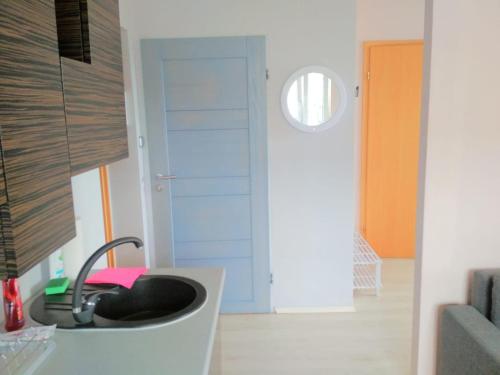 a kitchen with a sink and a hallway with a door at Apartament Puck in Puck