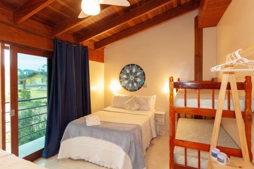 a bedroom with a bunk bed and a balcony at Ubatuba Ecologic Pousada in Ubatuba