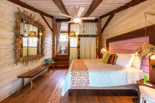 a bedroom with a bed and a mirror at Latica Lodge in Playa Negra