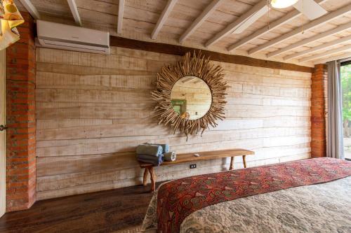 a bedroom with a wall with a mirror and a bed at Latica Lodge in Playa Negra