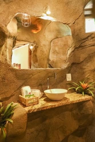a bathroom with a sink in a rock wall at Pousada Cantagalo in Itaipava